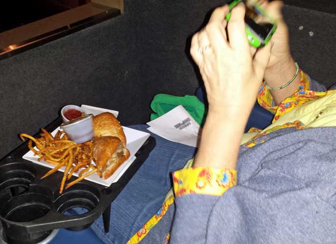 Gwen's meal tray, Behind: the leather seats on the theater floor