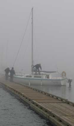 A noon-time fog rolls in causing navigation problems. The mast of the next sailboat is only 40 feet from this boat but can barely be seen in the fog.