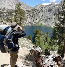 Merle photographs the Rae lakes basin, Behind: Katchan searching for a campsite
