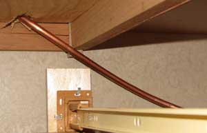 The copper tubing leads into a drawer space under the refrigerator