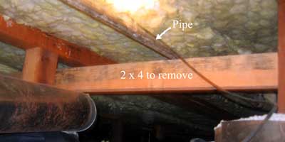 Remove the 2 x 4 to lower the pipe